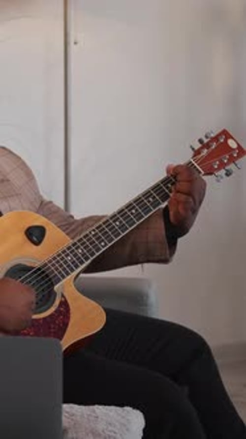 Man Playing Acoustic Guitar at Home