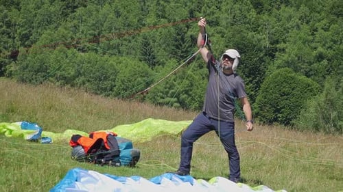 Paraglider Prepares His Parachute for Takeoff