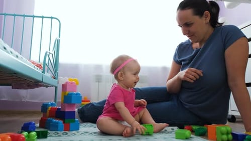 Happy Mother Playing with Baby at Home