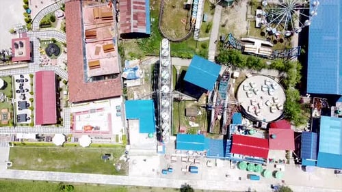 Un cautivador vídeo aéreo de arriba hacia abajo de un antiguo parque de atracciones, en el que se destaca una noria en movimiento.
La