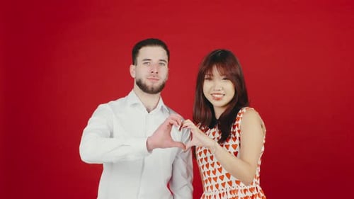 Young Couple Making Heart Shape with Hands