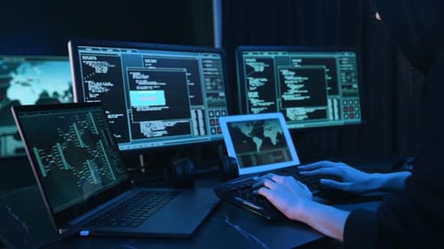 Hooded Figure Working on Computer at Night