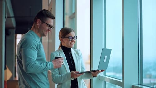Business Professionals Collaborating near Windows with Laptop