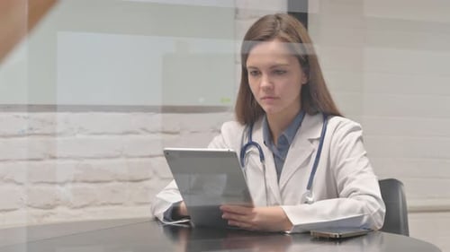 Female Doctor Using Tablet in Bright Office