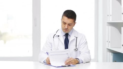 Man in White Coat Reads Patient Chart