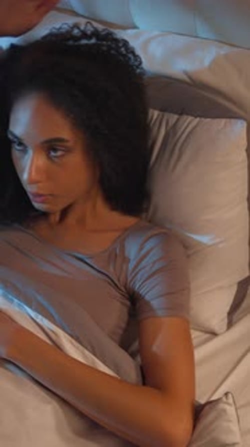 Femme afro-américaine nerveuse souffrant d'insomnie, faisant la sieste, difficultés à dormir au lit la nuit