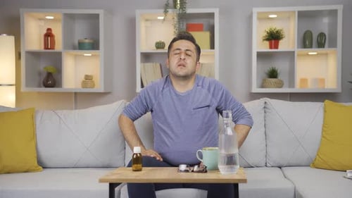 Man Feeling Sick on Couch at Home
