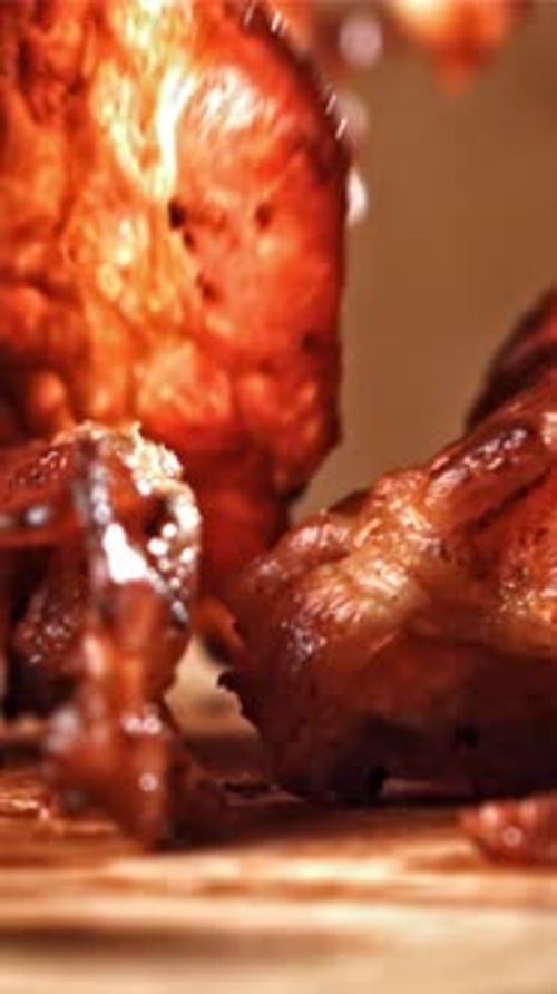 Roasted Slices of Bacon Fall on a Wooden Table Filmed on a Highspeed Camera at 1000 Fps