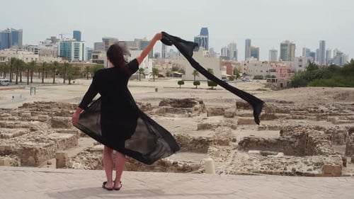 Vue arrière de la femme tenant un foulard debout sur un sentier