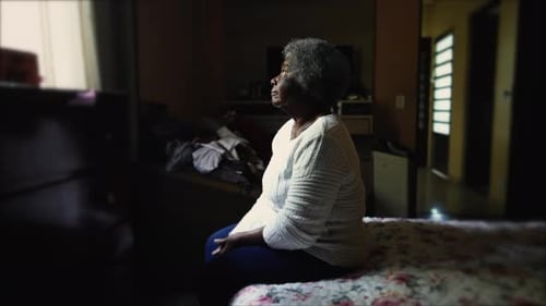 Senior Woman Sitting on Bed in Bedroom Thinking