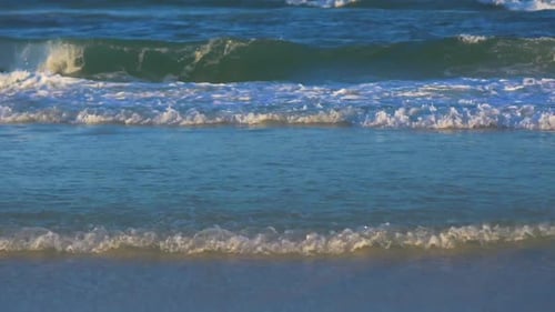 Eine intime Aufnahme von Wellen, die am Strand heranrollen