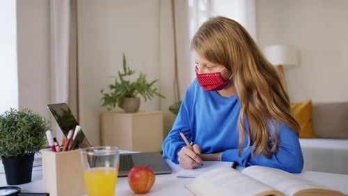 Girl Wearing Mask Studies at Desk Indoors