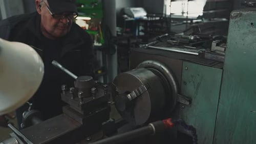 Adult Working on Metalworking Machine in Factory