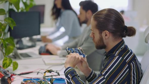 Man Worker Master Checks the Electronic Board Guy Holding Motherboard