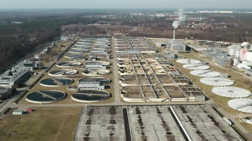 Sewage treatment plant featuring sludge digester domes and clarifiers