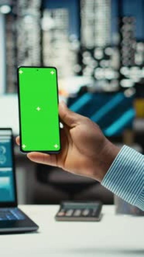 Vertical Video Black Professional Looks at Chroma Key on Mobile Phone Screen at Desk