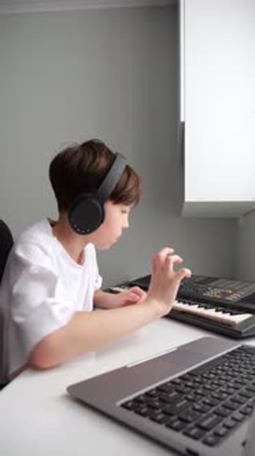 Young Child Plays Keyboard at Desk