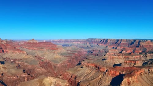 Atemberaubende Landschaft mit kahlen roten Canyons unter blauem, klarem Himmel.