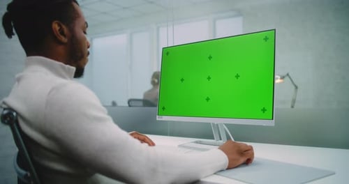 African American Financial Expert Enters Data on Computer with Green Screen Chromakey
