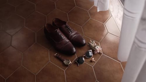 Groom's Accessories Arranged on Hexagonal Tile Floor