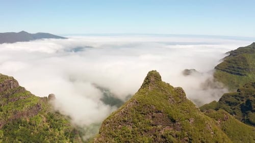 A smooth aerial drone shot soaring above a vast mountain range, highlighting dramatic peaks and swee