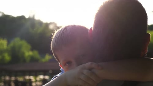 Loving Father and Son Embrace in Sunny Park