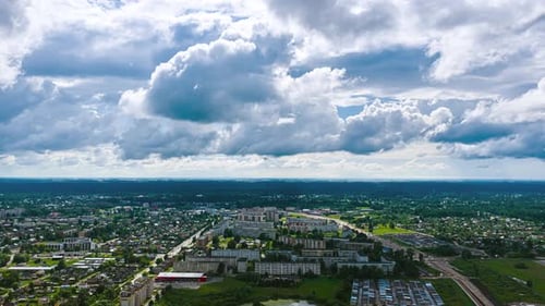 Aerial timelapse of a European city under fast-moving dramatic clouds, showing urban streets,