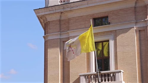 Vatican flag fluttering under blue sky
