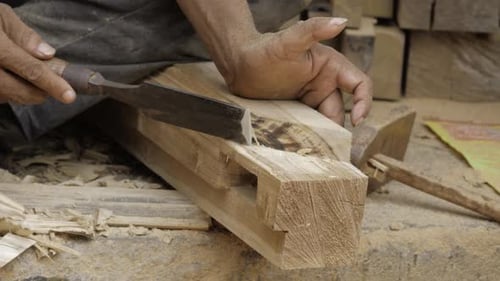 Woodworker Carefully Chiseling Design Into Piece of Wood