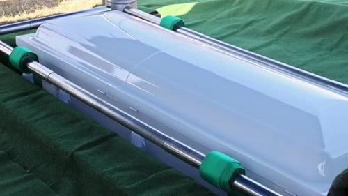 Casket Placed on Green Cloth with Metal Supports During Burial Service at Cemetery