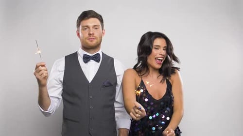 Elegant Couple Celebrating with Sparklers in Studio Setting