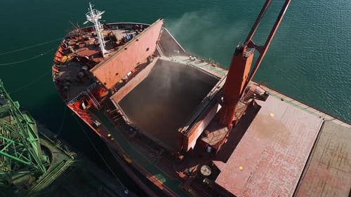 Aerial View of Big Cargo Ship Bulk Carrier is Loaded with Grain of Wheat in Port at Sunset