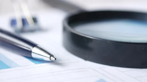 Financial Data and Magnifying Glass on Blue