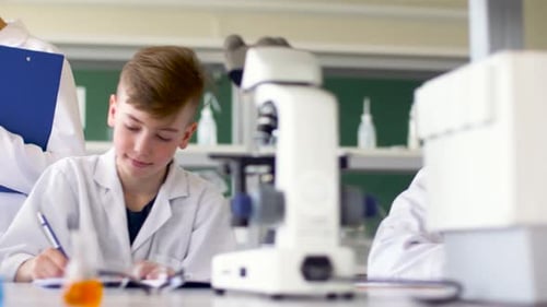 Education, Science And Children Concept - Teacher And Students Studying Chemistry At School Labor...