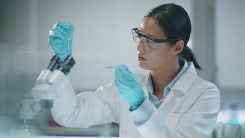Young Adult Woman Scientist Examining Test Tube in Lab