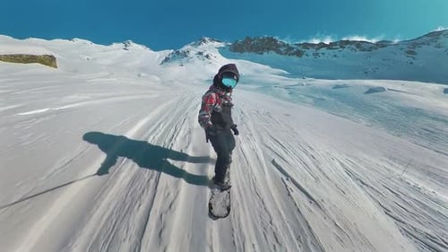 Pov view of Snowboard freeride. Professional snowboarder ride down the mountain slope at sunny winte