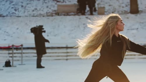 A Young Blonde Woman Figure Skater on Ice Rink