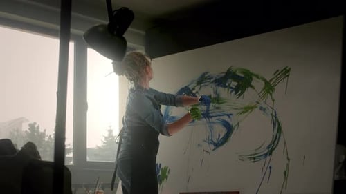 Female Artist Creating Abstract Painting in Studio