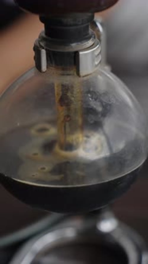 Coffee running into glass container after brewing, close up view