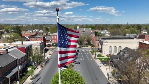 American Flag Waving Over Small Town Street