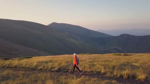 Tourist Hiker with a Backpack Walking on Mountain Path in Carpathian Mountains