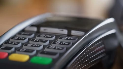 Caucasian man swiping bankcard at shop checkout for cashless payment slow motion