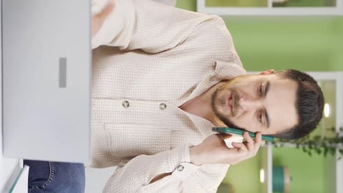 Man Talking on Phone While Using Laptop