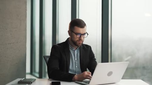 Professional Man Working at Laptop in Modern Office