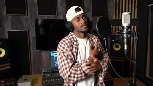 Young african american singer recording new album in professional studio