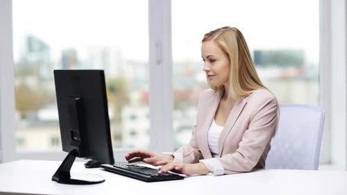 Young businesswoman typing on computer in modern office workplace