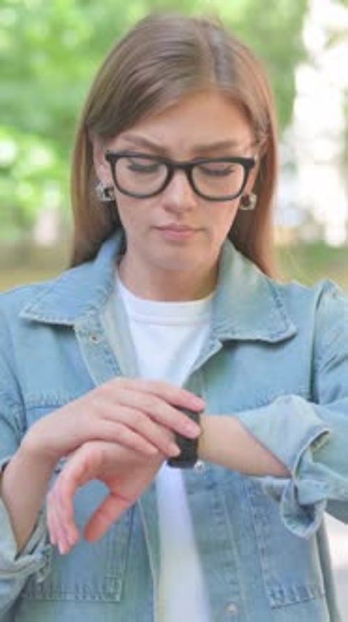 Woman checking the time on her wristwatch outdoors
