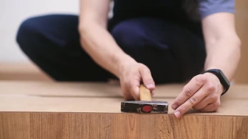 Commercial Carpentry Business Specialist Taking Nails to Hammer Into Wooden Wardrobe Close Up Hands