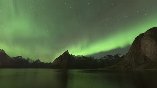 Time Lapse of strong aurora borealis dancing over the mountains in Hamnøy, Lofoten