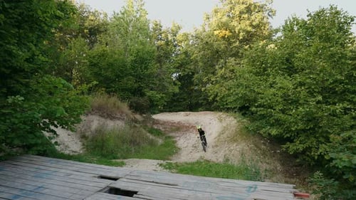 Downhill Mountain Biking in Forest Man on MTB Bike is Riding on Dirt Road in Woodland Doing Tricks
